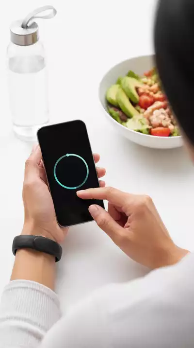 Person tracking their progress using a fitness tracker on a smartphone, clean white background, no text, no words