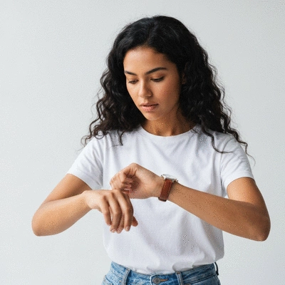 Person looking at a clock, emphasizing meal timing in Time-Restricted Eating