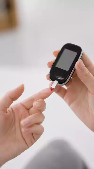 Person monitoring blood glucose levels with a device