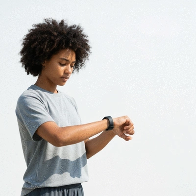 Person looking at a fitness tracker on their wrist, demonstrating mindful health monitoring, clean image